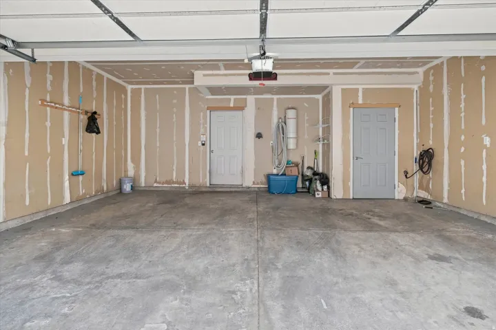 Concrete flooring with a segmented overhead garage door track system and two interior access doors