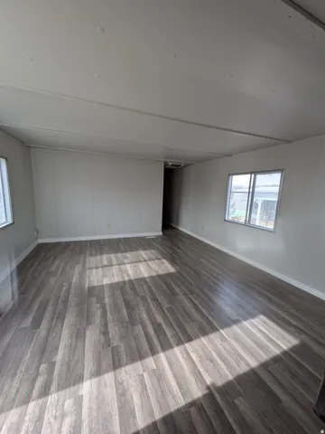 Wood-finish flooring, white paneled walls, recessed lighting, and multiple windows