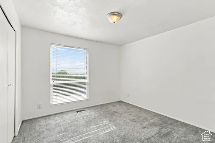 Recessed window with horizontal blinds, carpeted flooring, and a flush-mount ceiling light