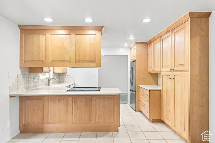 Kitchen featuring light wood cabinetry, recessed lighting, tile flooring, light-toned countertops, and a tile backsplash