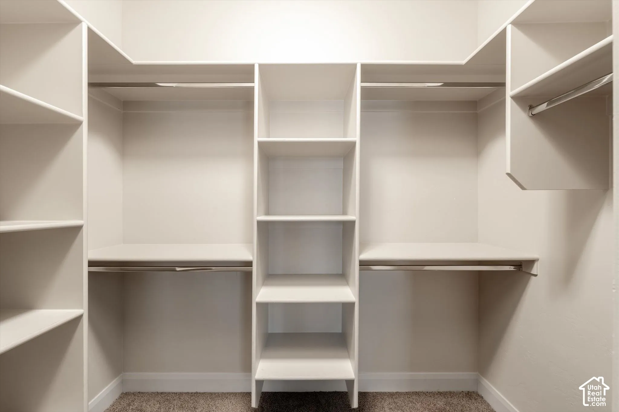 Integrated closet system featuring multiple shelving units, hanging rods, and a central tiered shelving column