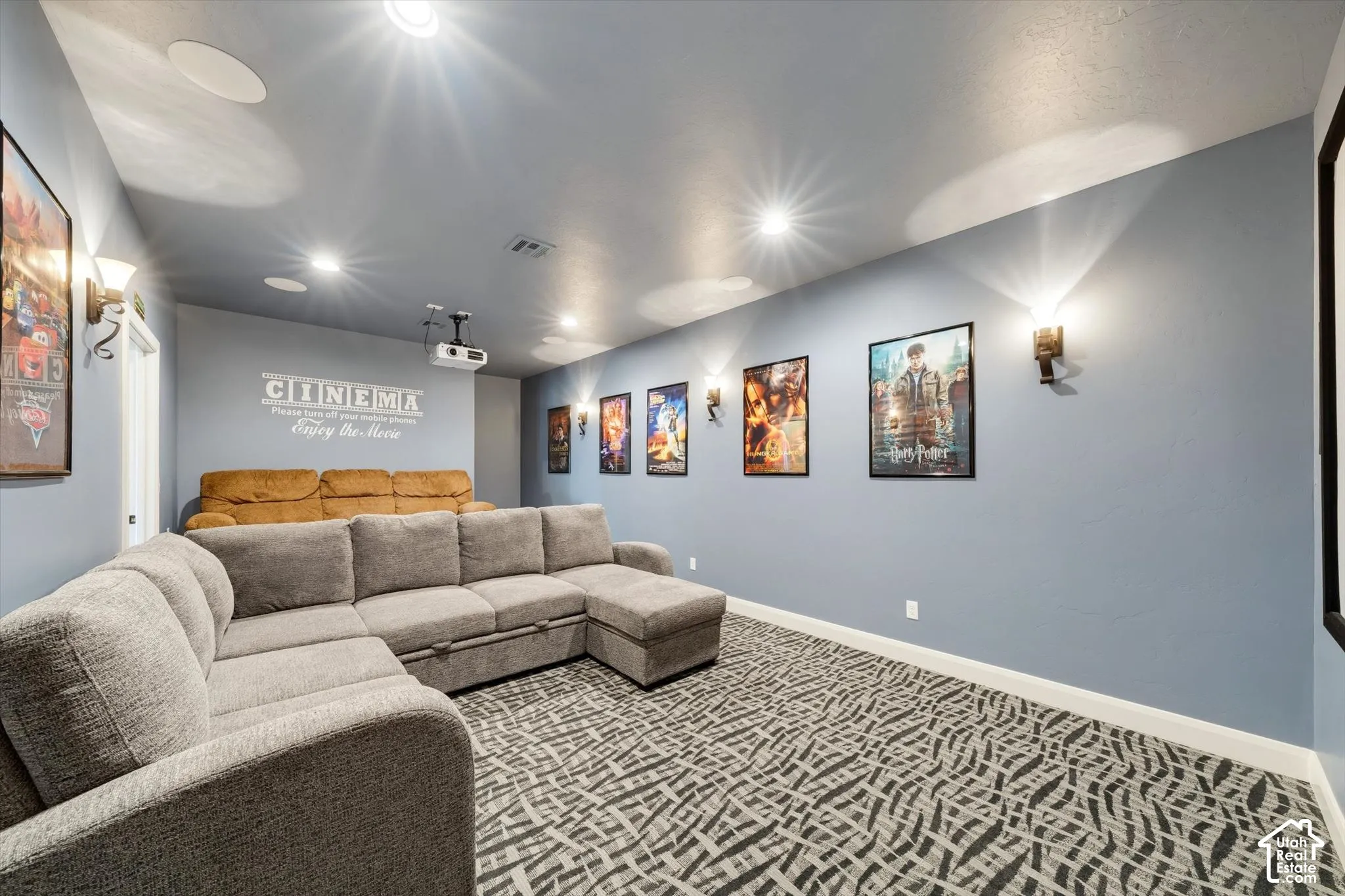 Recessed ceiling lighting, ceiling-mounted projector, wall sconces, ceiling-mounted speakers, patterned carpet flooring