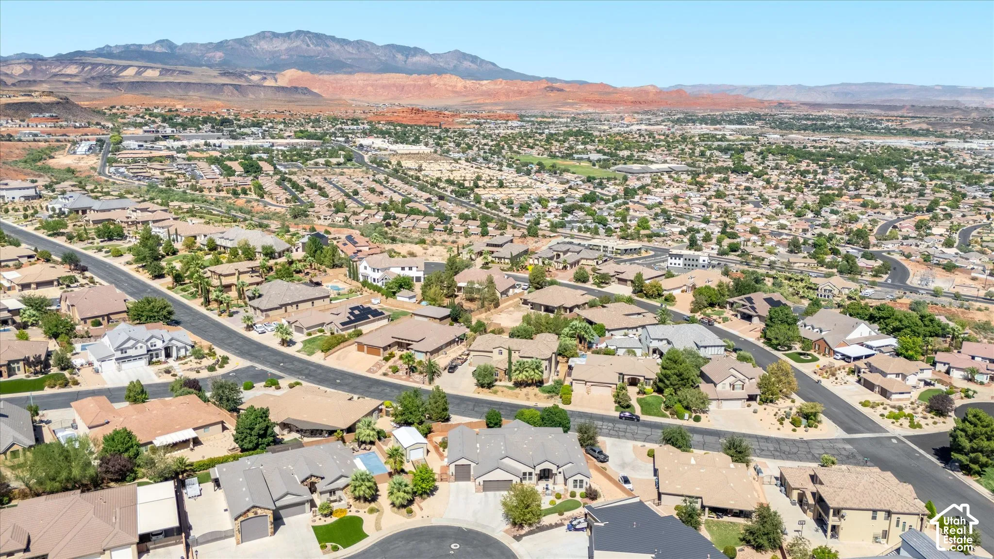 Expansive neighborhood setting with numerous residential properties, paved streets, and abundant mature landscaping