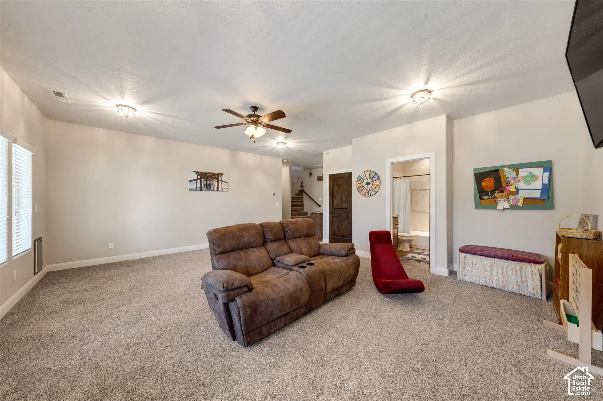 Carpeted living space featuring recessed lighting, a ceiling fan, and a window with blinds