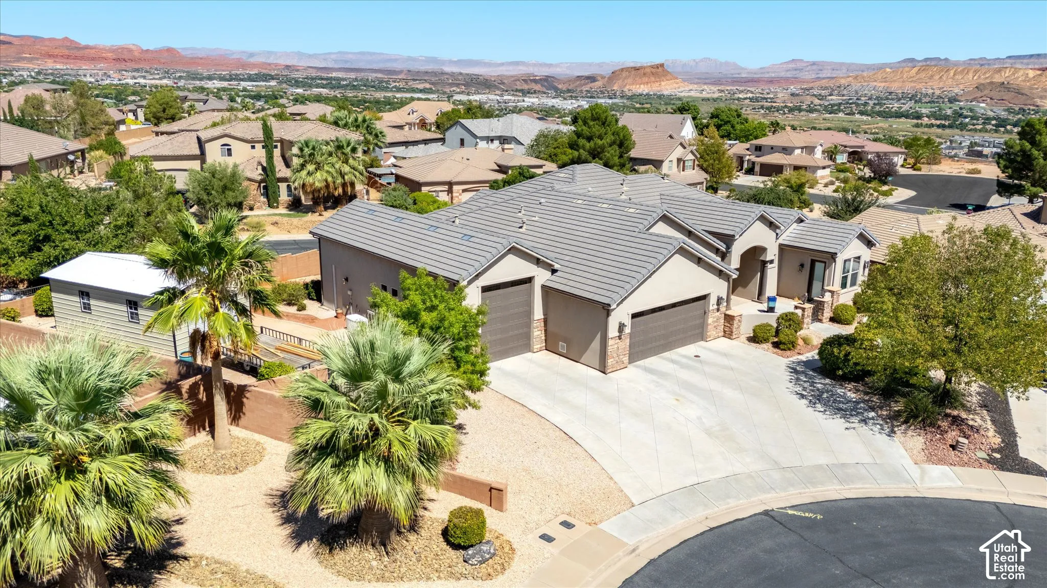 Neutral-toned exterior with a tile roof, a multi-car driveway, and mature landscaping