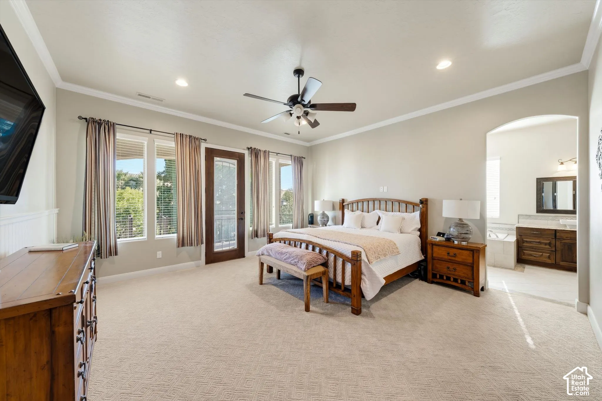 Recessed lighting, crown molding, ceiling fan, and multiple windows with a glass-paneled door