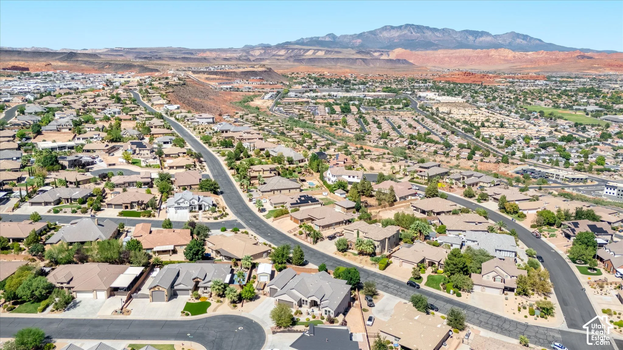 Extensive residential area with desert mountain backdrops, paved roadways, and mature landscaping