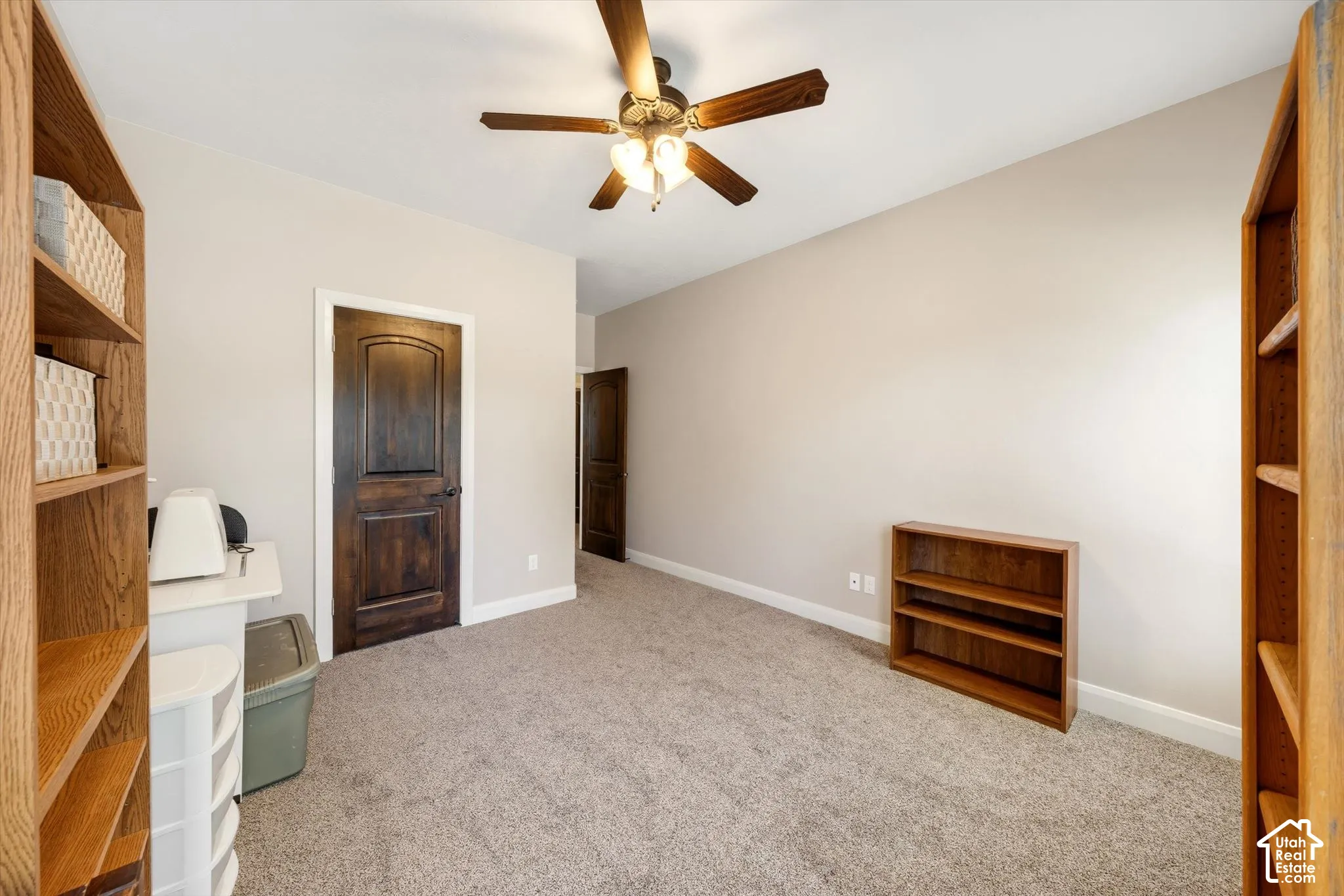 Neutral wall paint, ceiling fan with integrated lighting, and carpeted flooring
