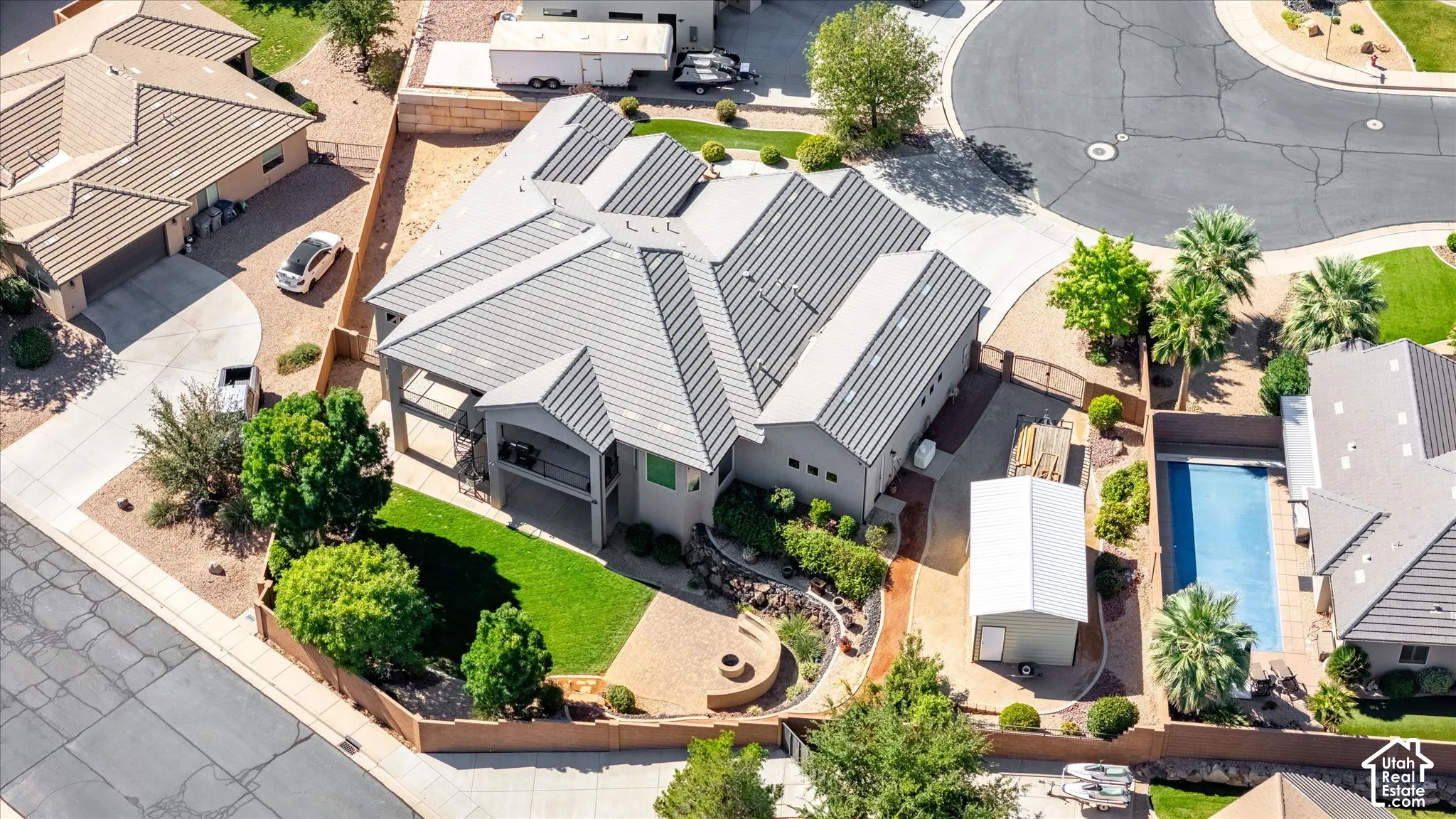 Expansive property featuring a swimming pool, detached shed, paved driveway, mature landscaping, and a fire pit