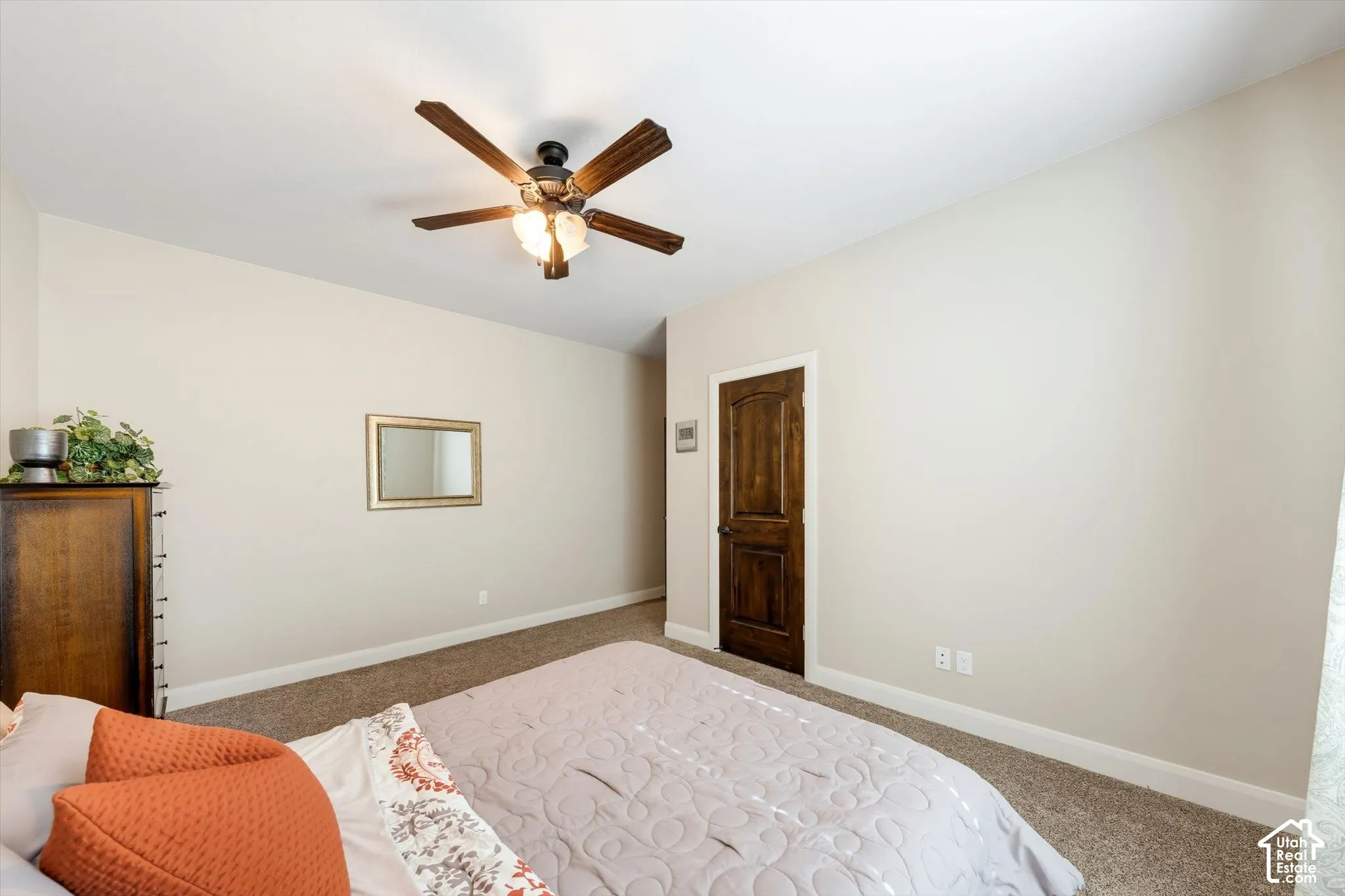 Recessed ceiling with an integrated ceiling fan, light-toned wall paint, and wood-finish interior door