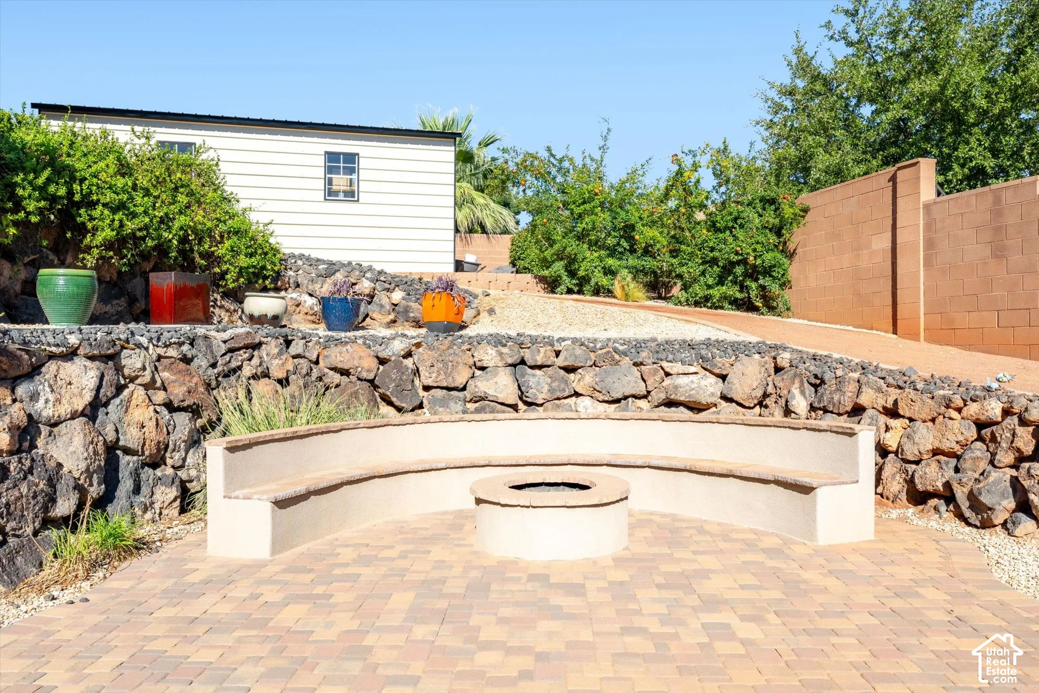 Paver patio with a built-in curved bench and fire pit