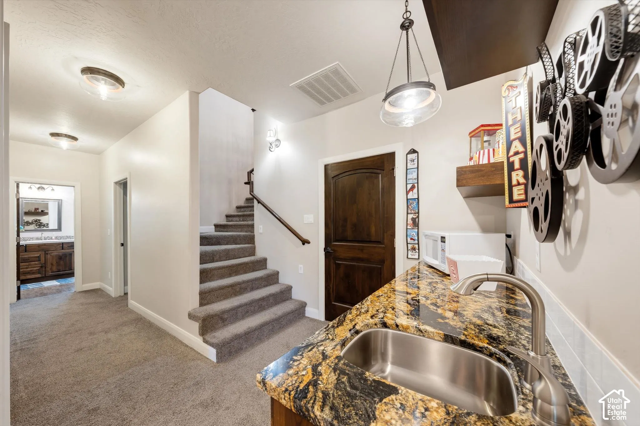 Wet bar featuring an undermount stainless steel sink, granite countertop, and brushed nickel faucet