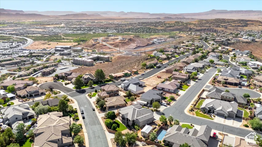 Expansive residential development with a variety of architectural styles, surrounded by natural desert landscapes and distant mountains