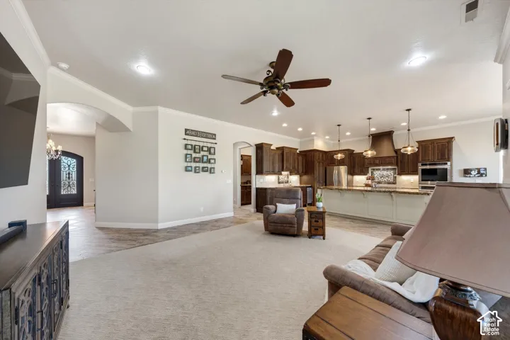 Open-concept living area featuring recessed lighting, a ceiling fan, and arched doorways