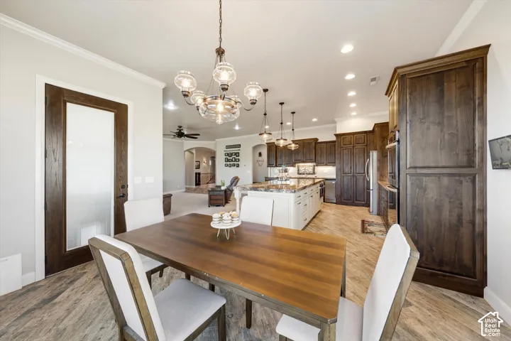 Open-concept dining area featuring a wood-finish table and an ornate chandelier