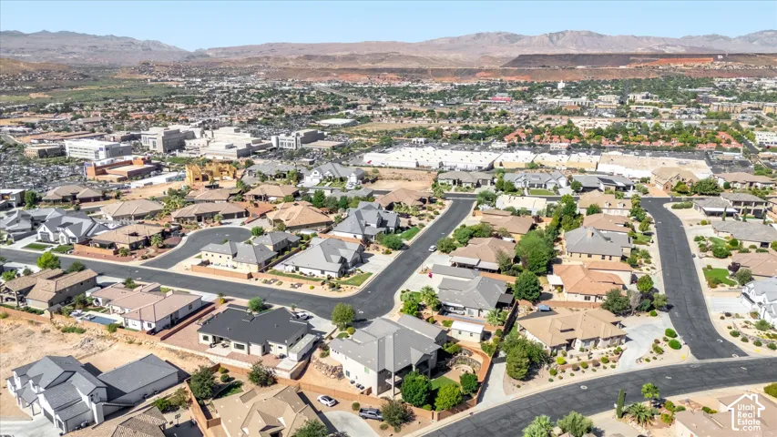 Expansive aerial showing residential community with varied rooflines and surrounding mountain landscape