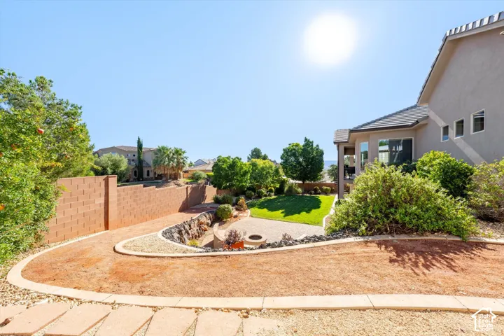Landscaped exterior featuring a terraced yard, concrete block retaining wall, and stone paver path
