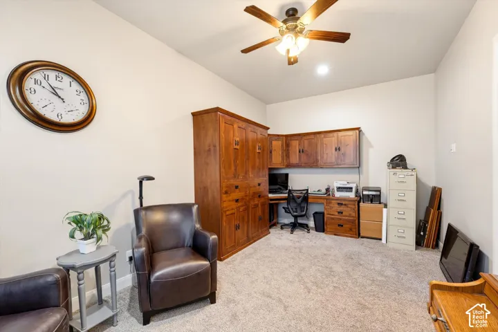 Built-in wood-finish cabinetry, wood-finish desk, recessed lighting, and a ceiling fan with integrated lighting