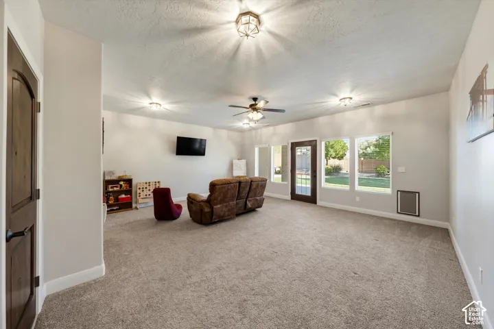 Expansive room featuring light-colored walls, recessed lighting, and a ceiling fan