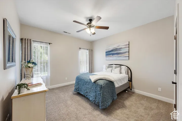 Carpeted flooring, vaulted ceiling, and two windows with blinds