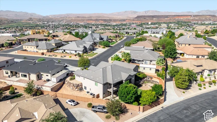 Residential community with varied architectural styles and desert landscaping, surrounded by distant mountains