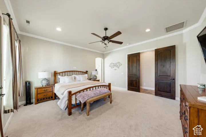 Recessed lighting, crown molding, ceiling fan, and sliding barn doors