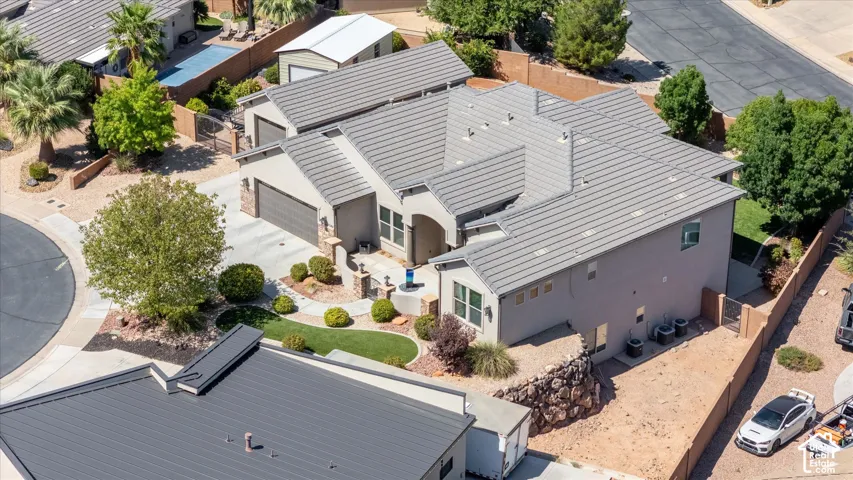 Stucco exterior with a tile roof, an attached two-car garage, and a concrete driveway