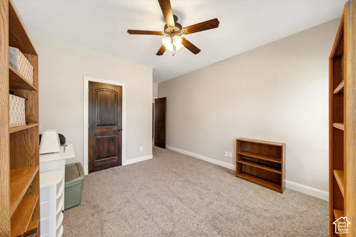Neutral wall paint, ceiling fan with integrated lighting, and carpeted flooring