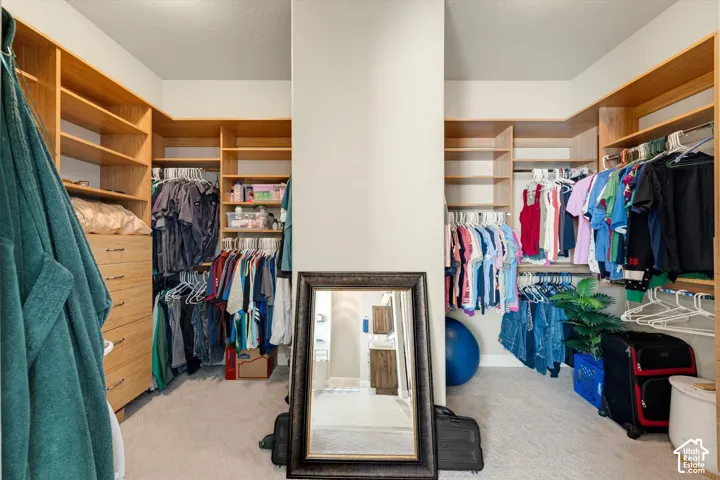 Expansive walk-in closet featuring extensive built-in shelving, hanging rods, and integrated drawer storage