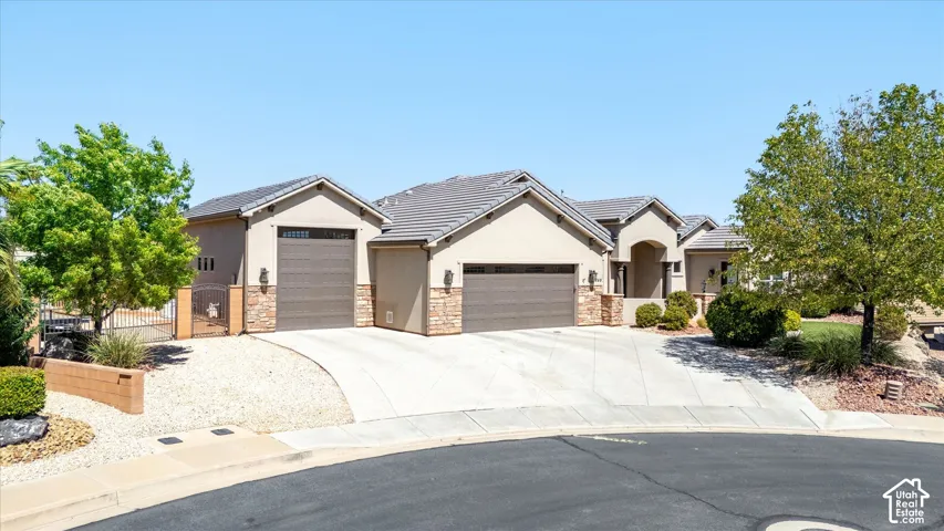 Stucco exterior with stone accents, two-car garage, and tiled roof