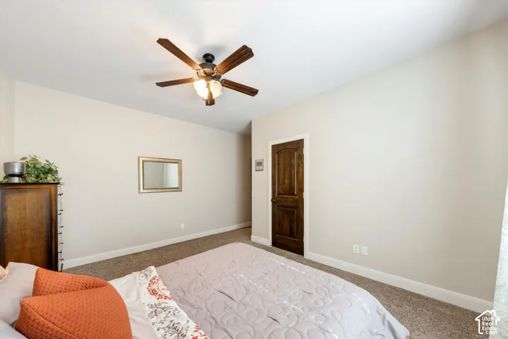 Recessed ceiling with an integrated ceiling fan, light-toned wall paint, and wood-finish interior door