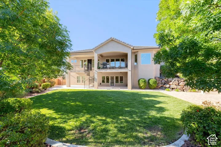 Expansive backyard with a manicured lawn, established perimeter landscaping, and mature trees