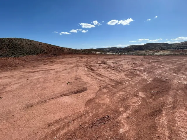 Expansive lot featuring cleared, level ground with a backdrop of rolling hills
