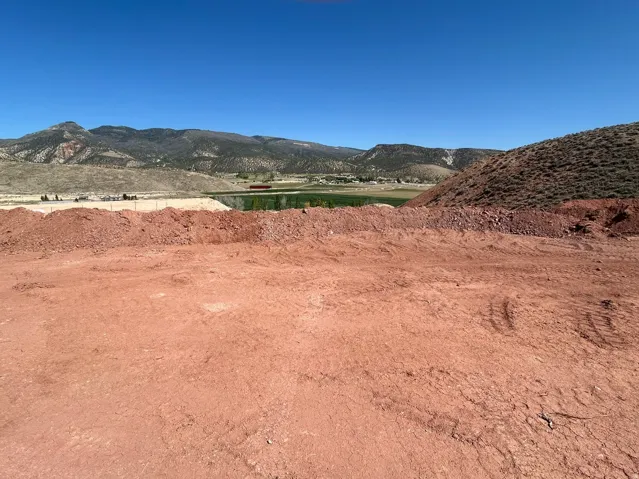 Expansive land parcel with mountain backdrop and clear sky