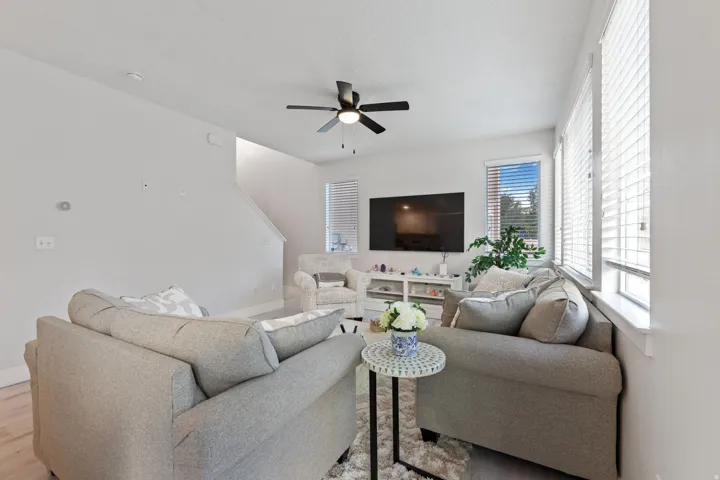 Recessed lighting, wood-finish flooring, staircase, and multiple windows with horizontal blinds