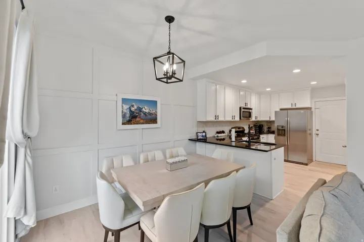 Modern kitchen featuring stainless steel appliances, white cabinetry, and a black countertop