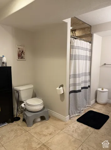 Tile flooring and shower with contrasting striped curtain