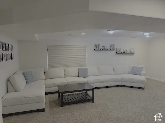 Carpeted recreational space featuring recessed lighting and a window with horizontal blinds