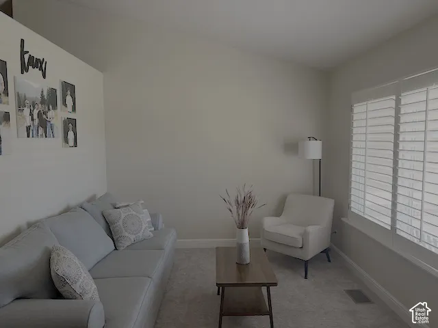 Vaulted ceiling, carpeted flooring, window with plantation shutters, recessed window sill, and neutral wall tones