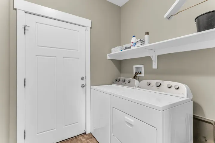 Laundry area featuring a paneled door, built-in shelving, and a washer and dryer