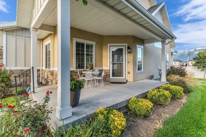 Covered concrete porch with white support columns