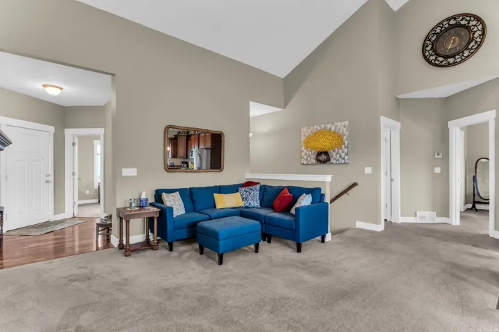 Vaulted ceilings highlight the neutral wall tones and carpeted flooring