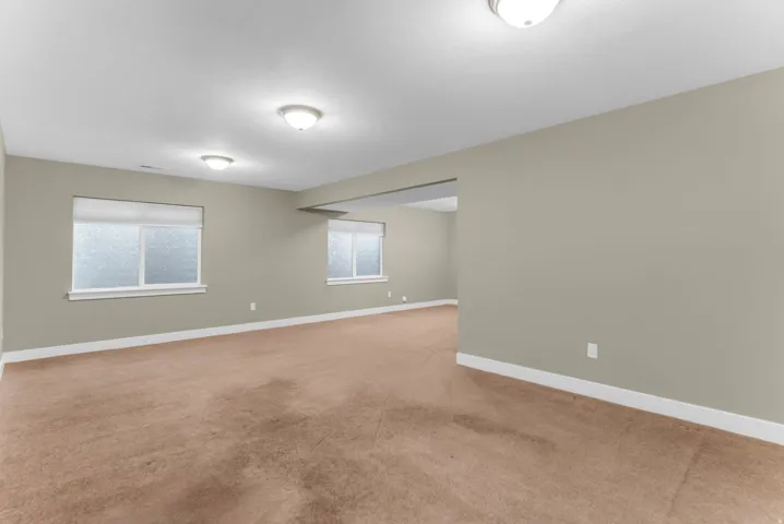 Expansive interior space with neutral wall paint and light brown carpet