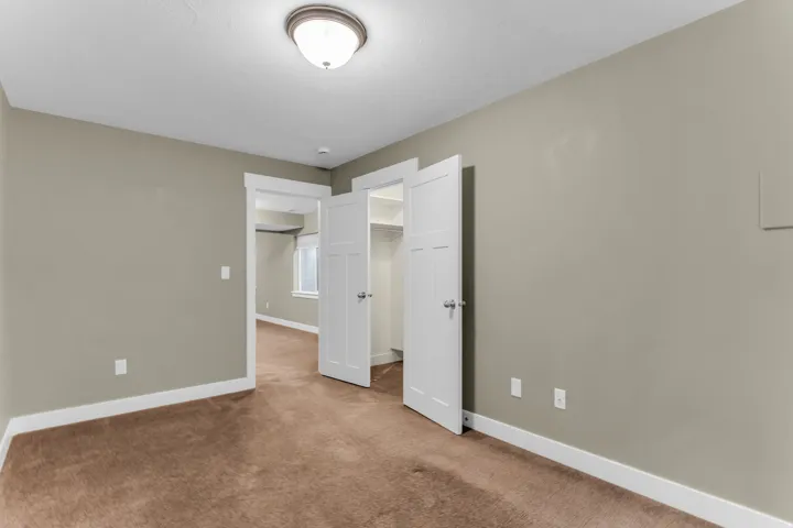 Recessed ceiling light fixture, neutral wall paint, white trim, brown carpet, white paneled doors