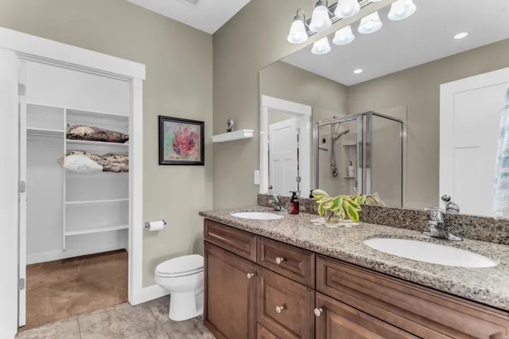 Dual vanity with granite-style countertop, individual sinks, and chrome faucets