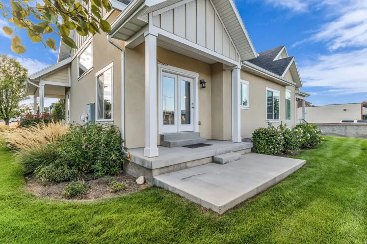 Back patio, stucco exterior with white trim, a concrete patio, and a covered entry