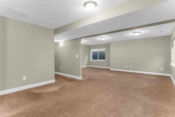 Expansive room featuring neutral wall tones, recessed lighting, and carpet flooring