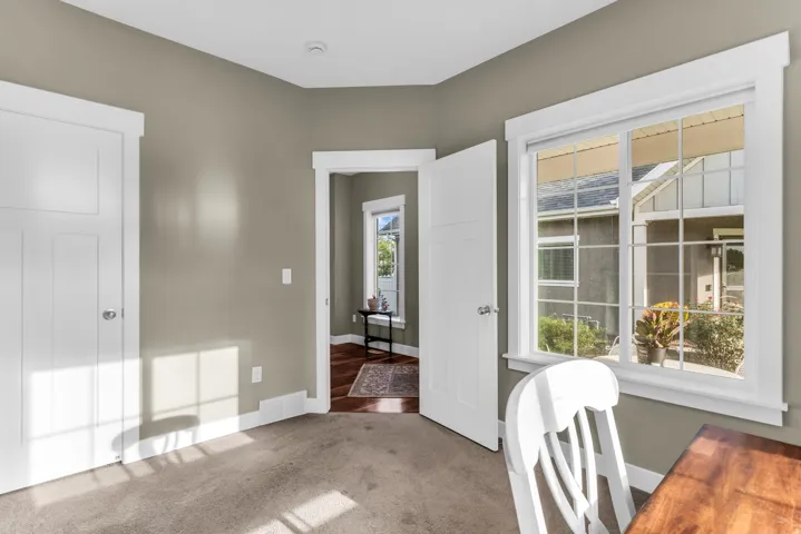 Neutral paint palette with white trim, a multi-pane window, and carpet flooring