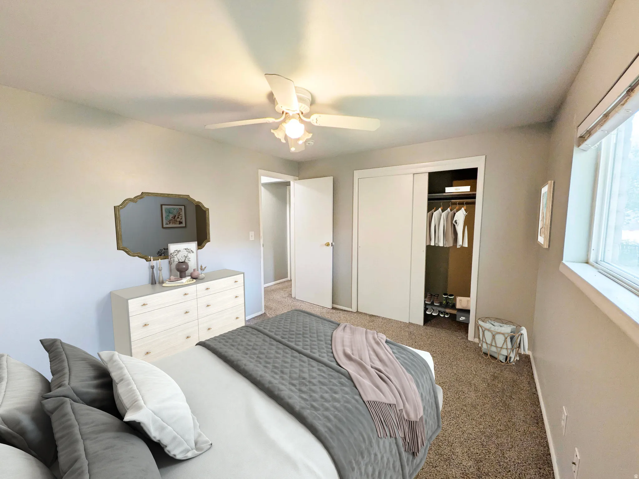 Carpeted flooring, ceiling fan with light fixture, sliding closet doors, and window with trim