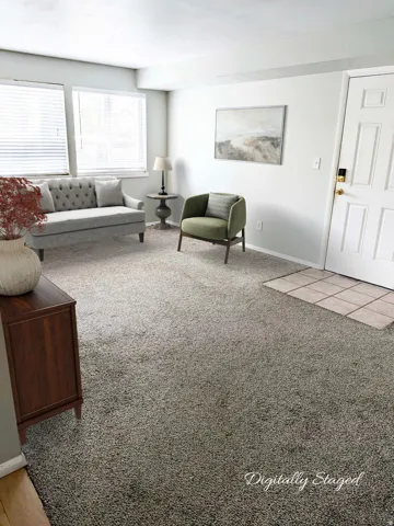 Light gray carpeting, white walls, and a multi-panel entry door with brass hardware